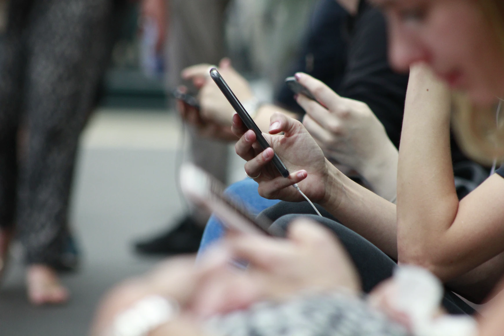 Several hands holding smart phones